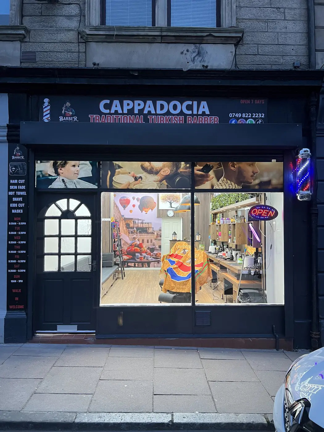 The lit shopfront of Cappadocia Traditional Turkish Barber on South Street, Bo'ness